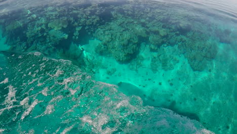 Moviéndose-Más-Allá-De-La-Cabeza-Del-Arrecife-De-Coral-Debajo,-Agua-Azul-Clara,-Estela-De-Barco-De-Mano