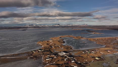 aerial view of frozen lake mývatn with skútustaðir and snowy mountains in reykjahlíð. iceland