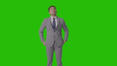 Three-Quarter-Length-Portrait-Of-Serious-Businessman-In-Suit-Against-Green-Screen-