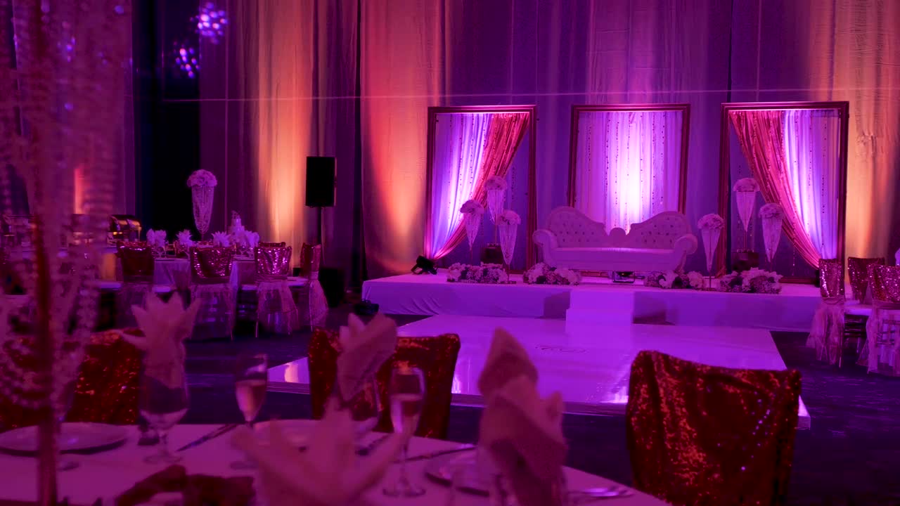 una toma lateral deslizante de un sofá en un escenario en una recepción de boda