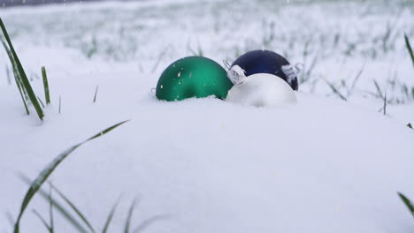 Throwing-three-Christmas-tree-toys-into-pure-white-snow-during-snowfall