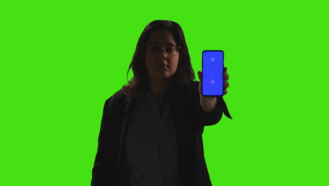 retrato de estudio de una mujer de negocios con gafas de pie contra la pantalla verde con las manos en las caderas