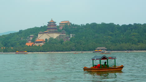 pequeño barco turístico navegando en el lago del palacio de verano, beijing