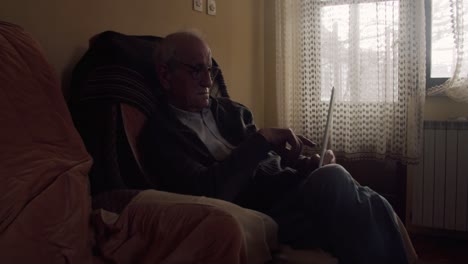 Anciano-Usando-Una-Tableta-Slomo-Travelling-Shot