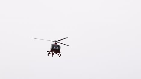 a helicopter flies over the scenic great ocean road, captured in clear daylight with a focus on aerial movement and landscape