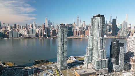 aerial pullback away from the east river in queens with manhattan borough in background