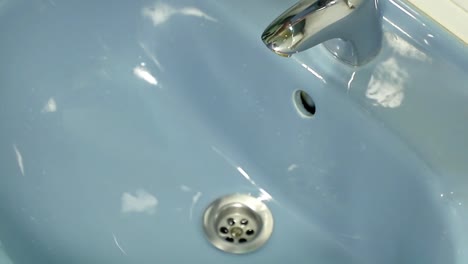 hombre lavándose las manos en el lavabo del baño con jabón