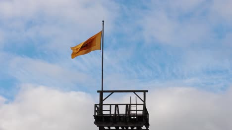 yellow flag waving against blue sky