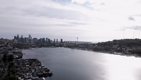 The-bright-sun-reflecting-off-a-panoramic-view-of-Lake-Union-and-downtown-Seattle,-aerial