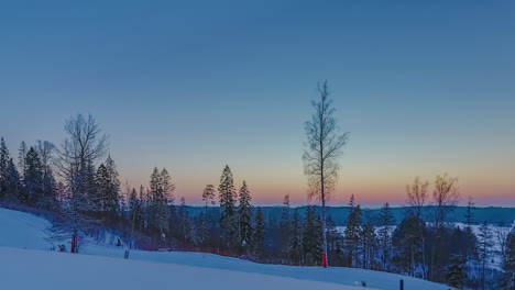 Sunset-at-a-ski-slope---sliding,-rising-motion-time-lapse-to-reveal-the-skiers-and-snowboarders