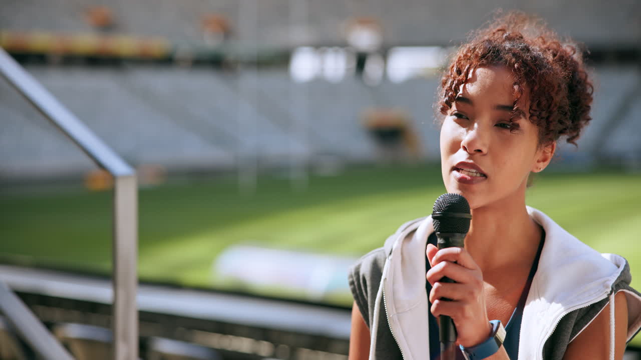 Woman Speaking into a Microphone at a Stadium