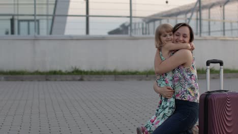 madre se reúne con su hija cerca de la terminal del aeropuerto con los brazos abiertos después de un largo viaje de vuelo