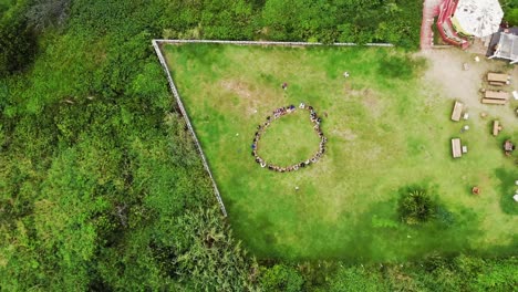 aerial top down showing circle of people doing morning sport outdoors in garden at beach