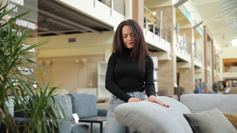 young woman hugging soft pillow on stylish sofa in furniture store young woman enjoying a cozy peaceful moment hugging a soft pillow on a stylish sofa in a furniture store