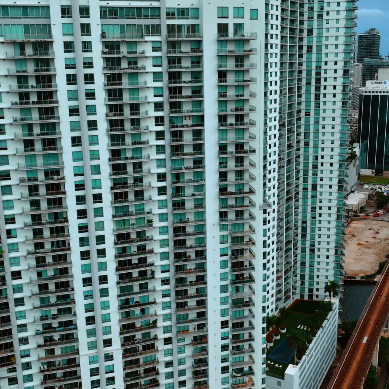 Multi-apartment high-rise building in the residential area. Miami downtown block of flats from top view.
