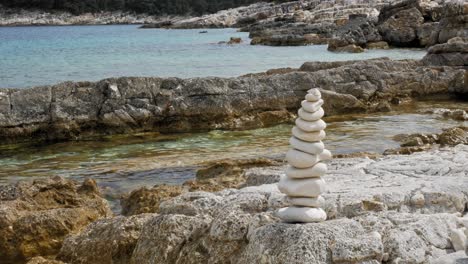 stack of stones on the sea beach of paralia emplisi in greece - static shot