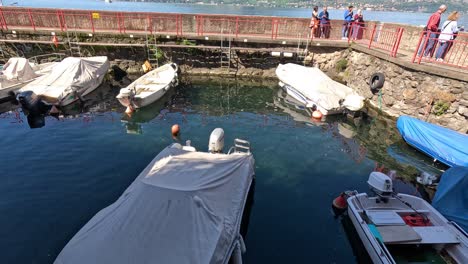 boats docking and people observing in varenna