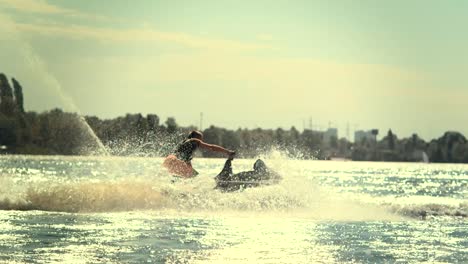 sportsman swirling on speedy jet ski at sunset in slow motion