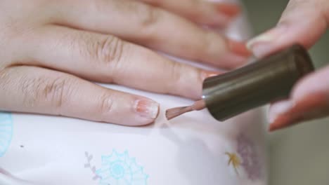 closeup of a woman paints her nails by self made manicure at home slow motion scene