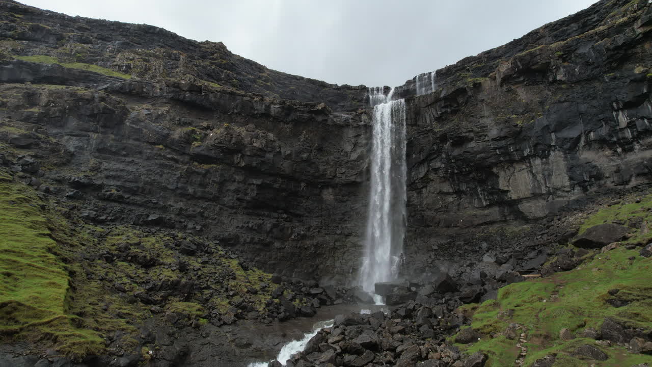 Beautiful Fossa waterfall :Powerful waterfall cascading down a sheer rock face covered with green moss in a stunning landscape