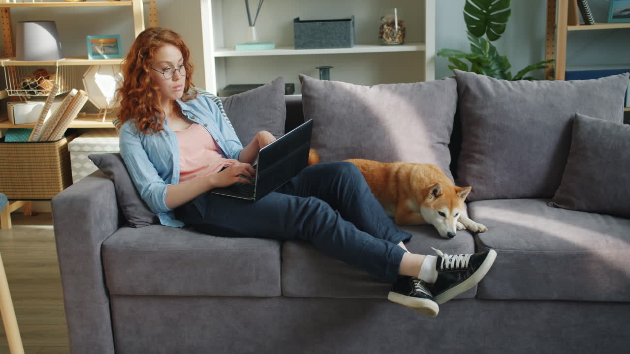 Woman Working from Home with Dog on Sofa