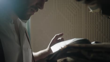 man reading newspaper in dim room