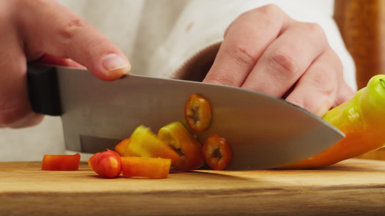 Close-Up of Hand Slicing Fresh Sweet Pepper on Cutting Board