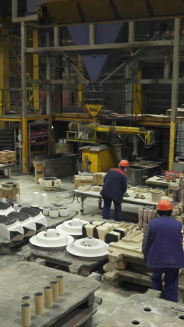 industrial metal casting process with workers in a foundry