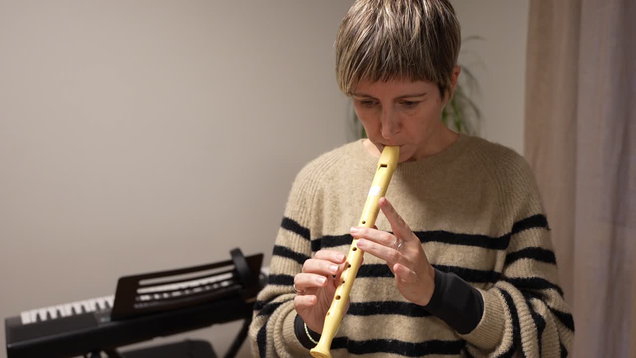 Donna concentrata che suona un flauto dolce