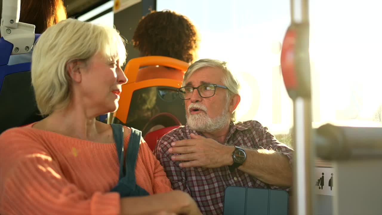 Elderly couple conversing on a bus