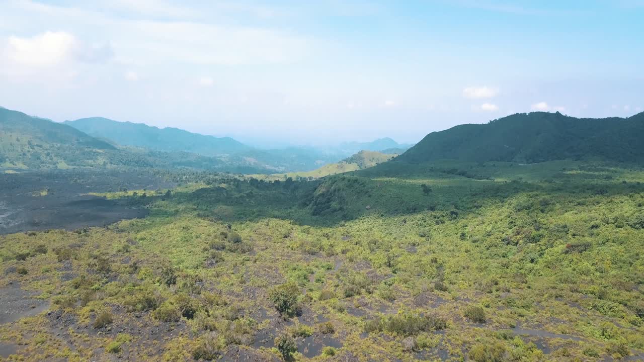 toma aérea de un dron que revela un paisaje arenoso con montañas verdes cerca del volcán pacaya en guatemala