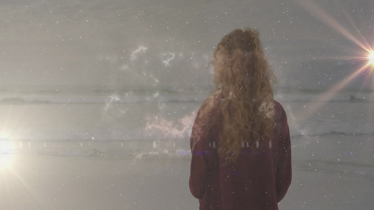Eine Frau am Meer blickt zum Horizont und aktiviert Tech-Sterne mit Glitch-Linien, die das Licht kreuzen.