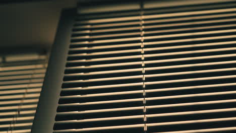 horizontal blinds on window in dark room low angle shot