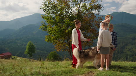 Fröhliche-Husky-Familie,-Die-An-Einem-Bergsommertag-Unterwegs-Ist.-Menschen-Haben-Spaß-Mit-Haustieren.