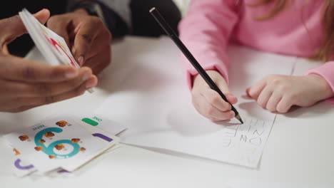 english teacher holds card schoolgirl writes digit name