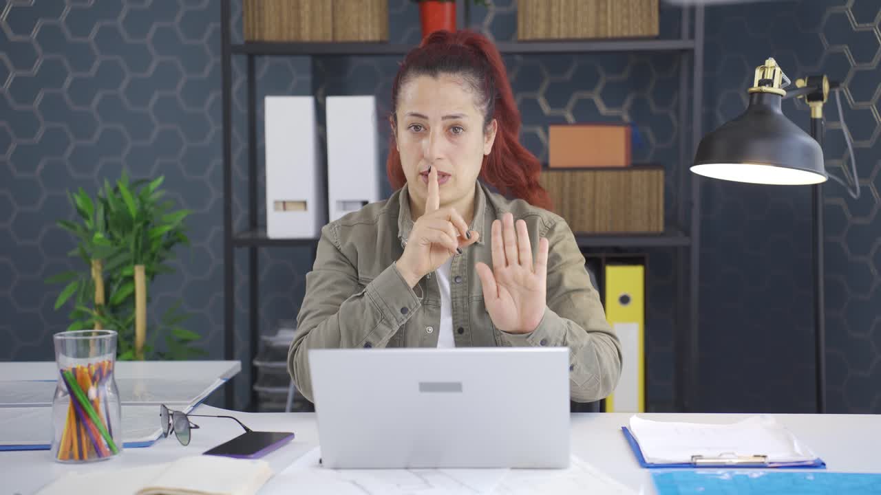 una mujer de negocios le dice a la cámara que se calle.