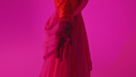 Close-Up-On-Hands-And-Feet-Of-Female-Kathak-Dancer-Performing-Dance-Wearing-Traditional-Indian-Dress-Against-Purple-Background