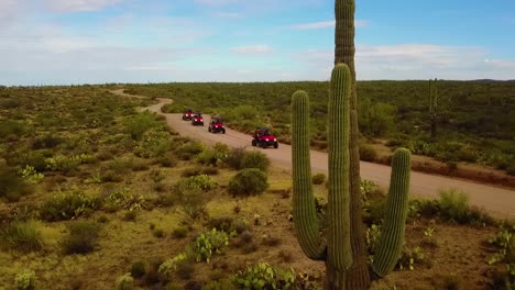 aerial drone shot that pans with some utv's cruising through the arizona desert on a cloudy day