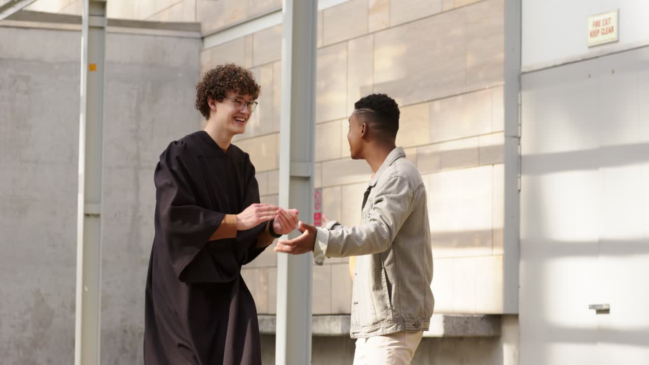 Amici di diverse etnie che festeggiano la laurea in cortile lanciando il tocco, abbracciandosi e camminando.