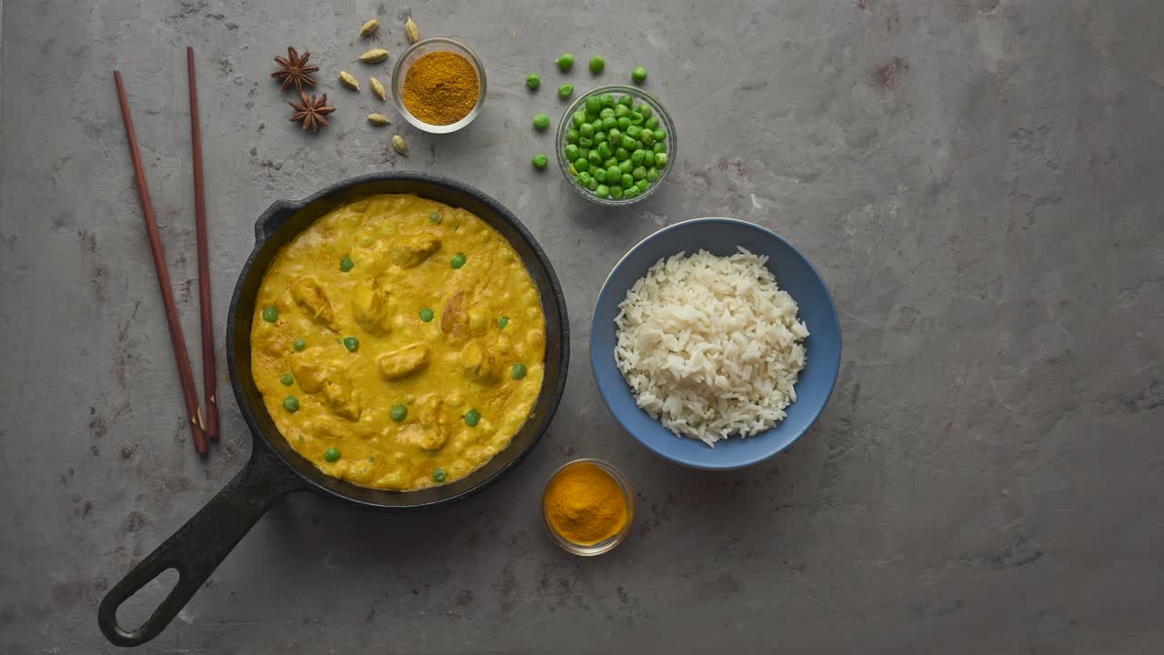 bucle de cinemagraph. cocinar delicioso curry de pollo en sartén con especias. colocación plana, vista superior con espacio de copia