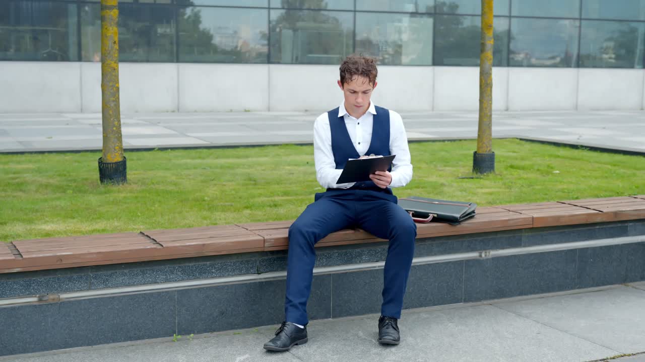 Caucasian Young business analyst expressing frustration, throwing a document away while sitting on an outdoor bench, feeling stressed and annoyed with failed business