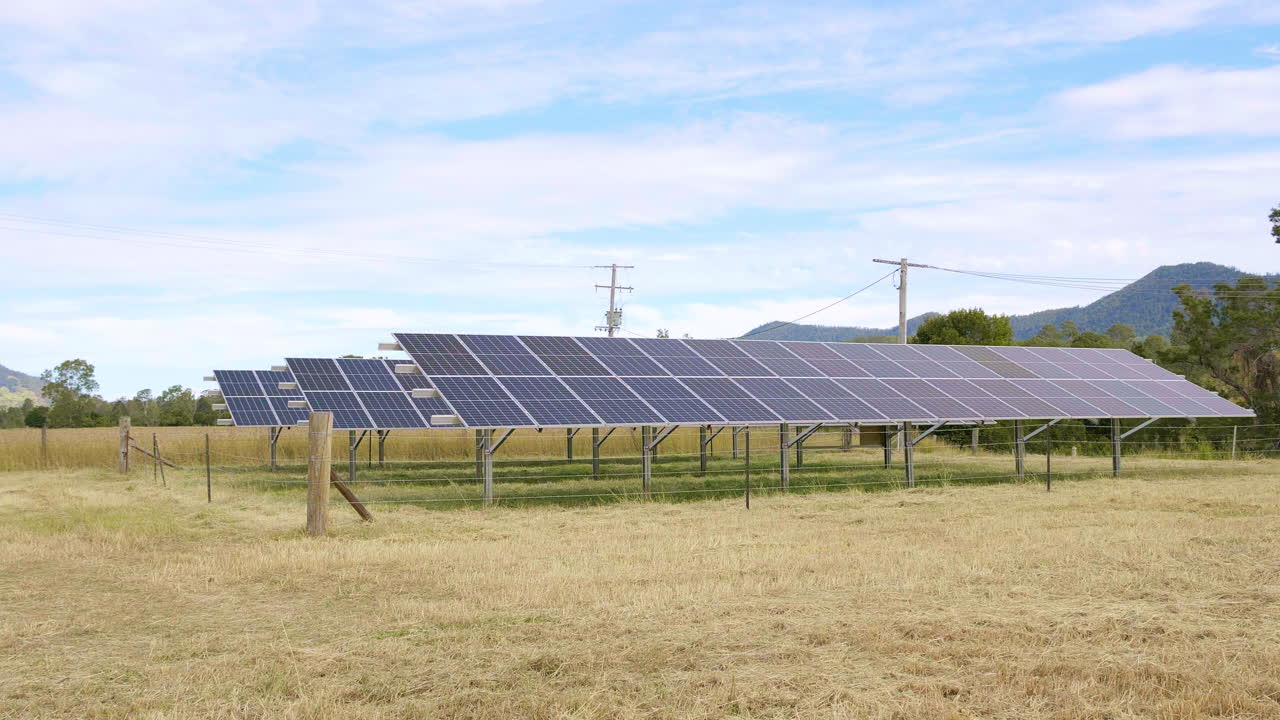 filas de paneles solares en un paddock rural australiano con cielo azul, drones 4k