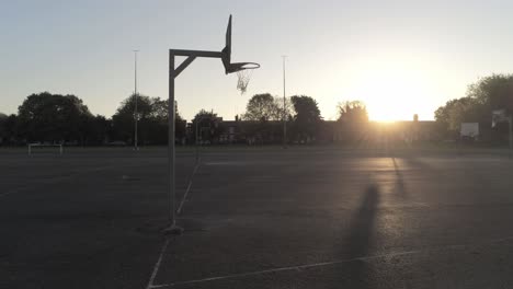 sunrise shadow silhouette empty basketball court dolly low right