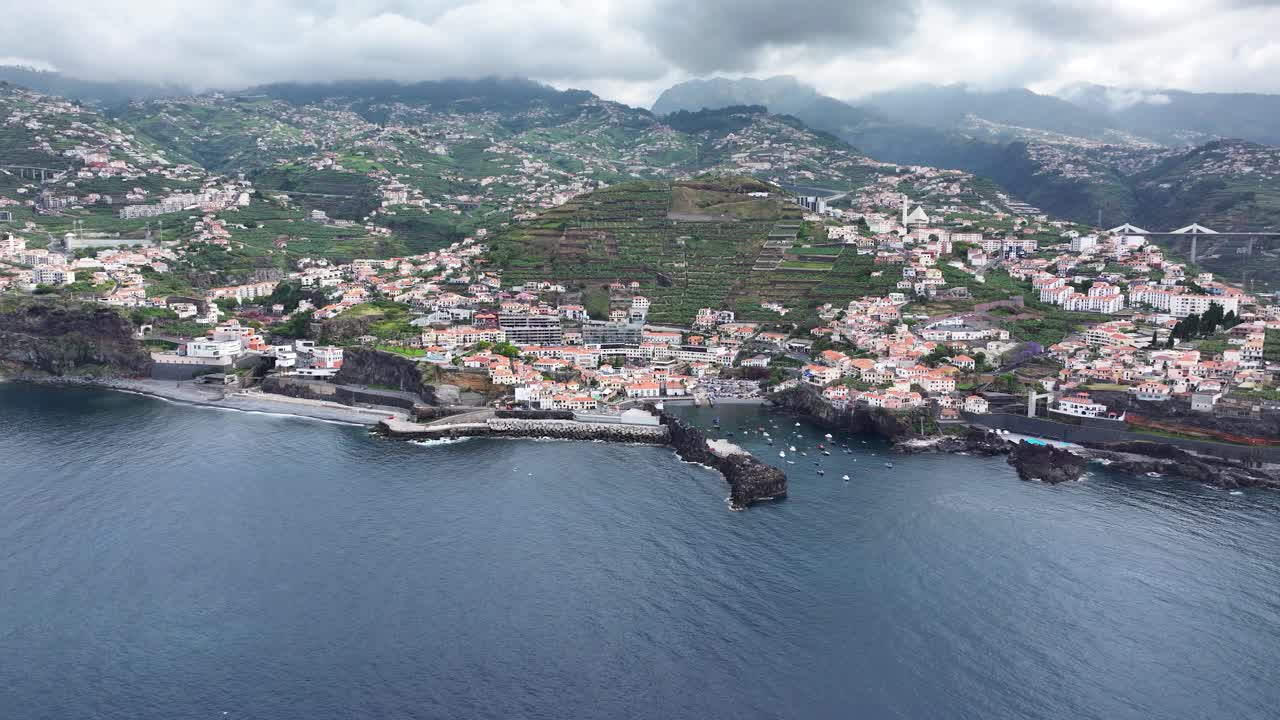 Porto di pesca di Câmara de Lobos e costa con edifici sulle colline, vista aerea