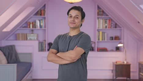 retrato de un hombre indio feliz de pie con las manos cruzadas