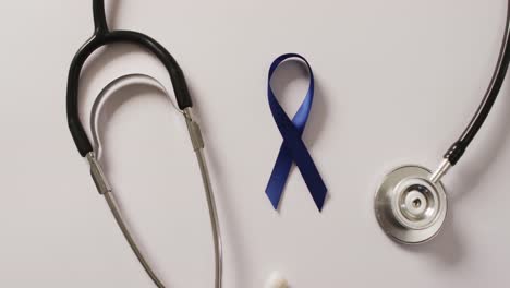 Video-of-stethoscope-and-dark-blue-colon-cancer-ribbon-on-pale-blue-background