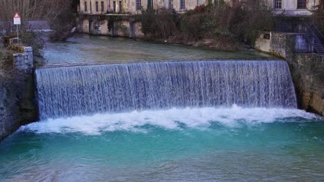 A-gushing-river-cascades-over-a-waterfall-flowing-through-the-center-of-Rovereto-in-the-alps