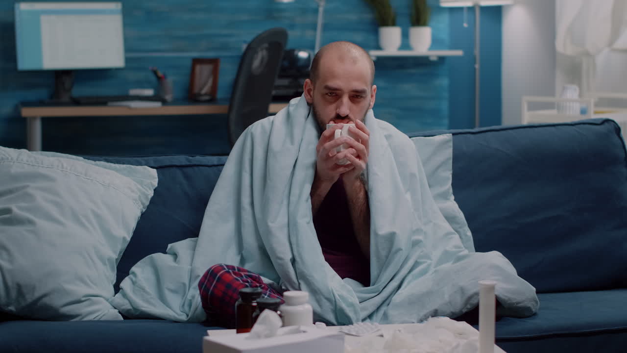 Man with sickness holding cup of tea to cure cold and flu