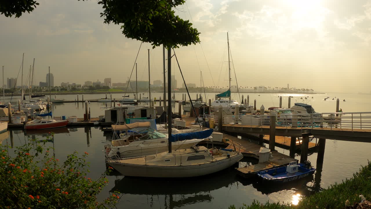 항구에 정박한 범선은 고요한 바다 표면에서 반사되는 일몰과 함께 - 슬라이딩 뷰