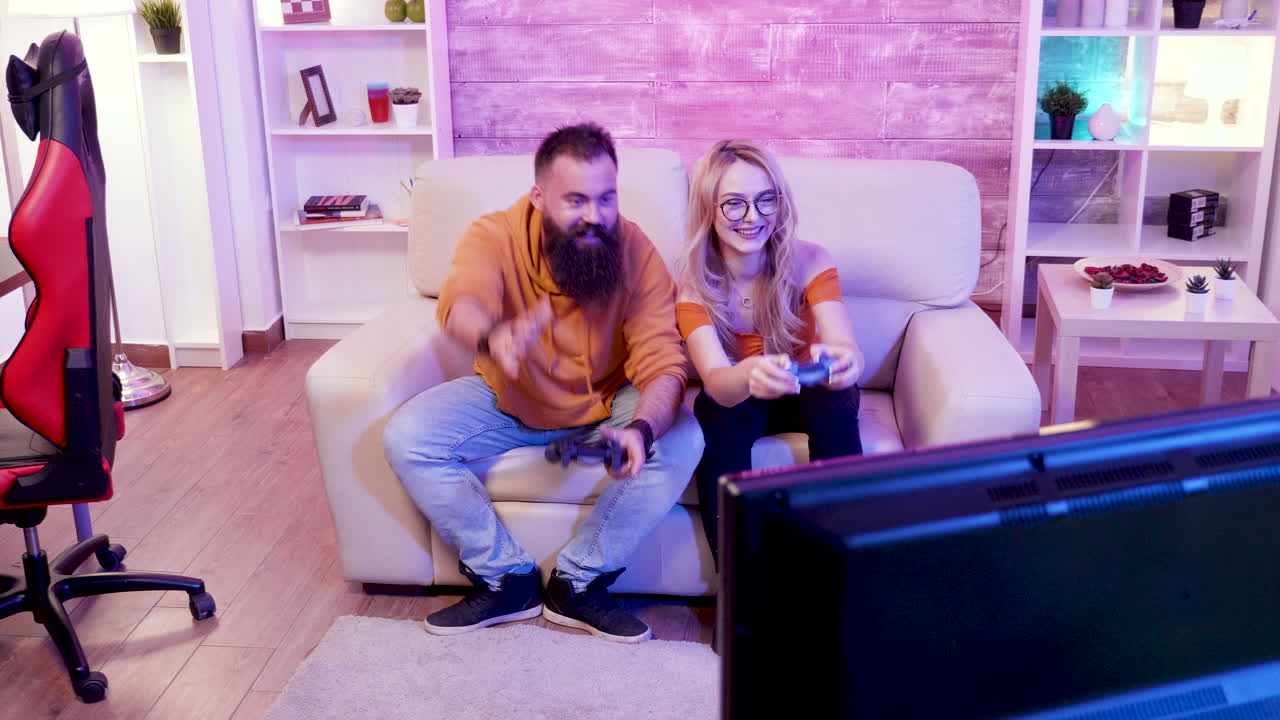 una pareja jugando videojuegos en el sofá.